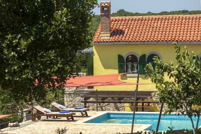 Žuto pročelje vile s pogledom na bazen