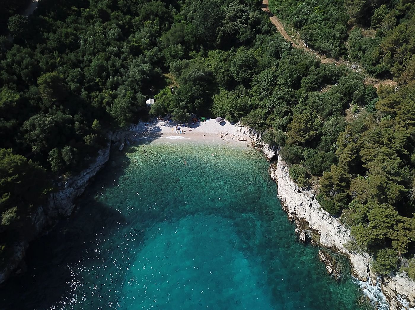 Šljunčana uvala okružena borovom šumom, iz zraka
